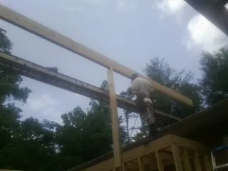 Carpenter setting a ridge beam over a new addition frame — Ice Dam Removal by Roofing Brothers in Quaker City