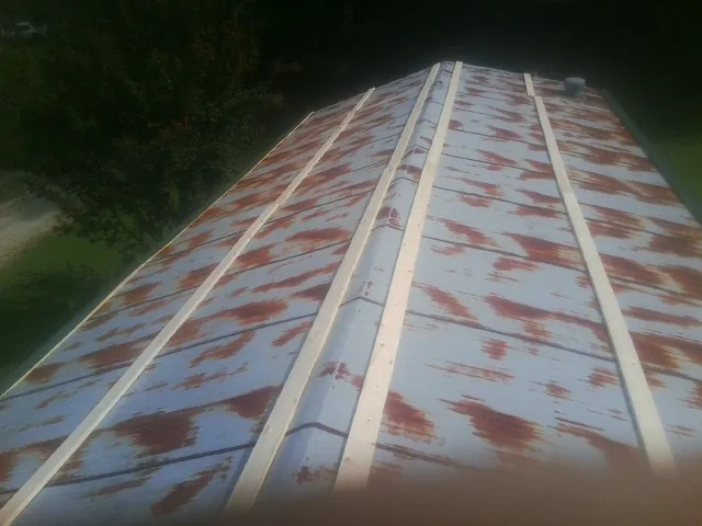 Rusted metal roof panels with new wood purlins before replacement — Storm Damage Roof Repair in Quaker City by Roofing Brothers