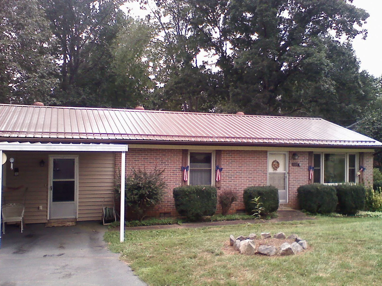 Bronze metal roof and carport on a brick ranch home — Roof Repair work by our crew in Quaker City