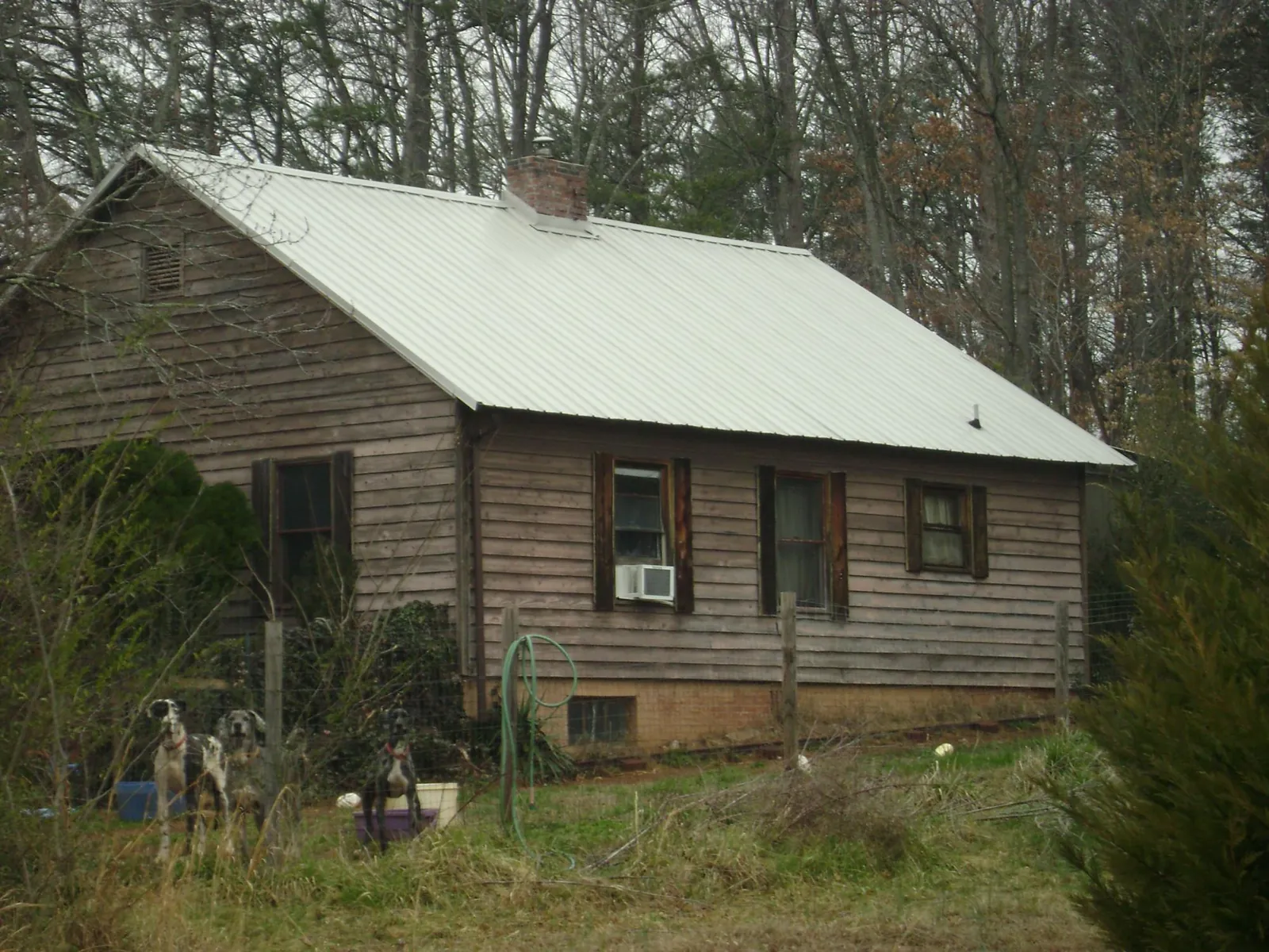 White metal roof on an old wood sided farmhouse, from a Metal Roof Installation job in Quaker City